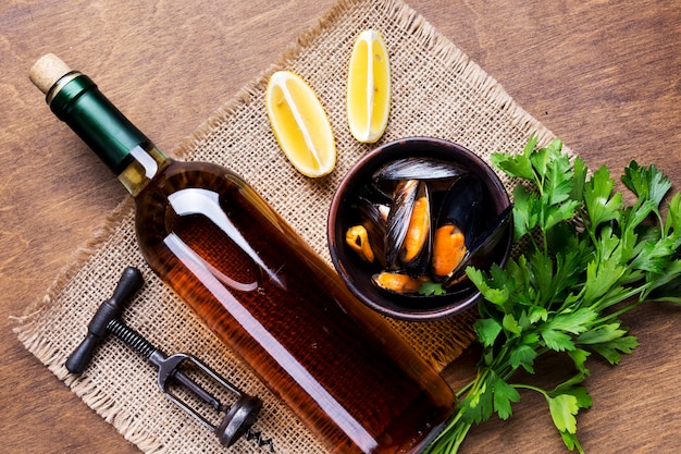 Foto gratuita mejillones cocidos de plano y botella de vino.