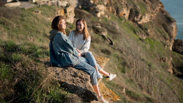 Las mejores amigas sentadas en una colina