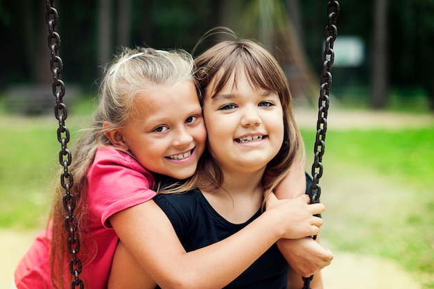 Mejores amigos balanceándose en un parque