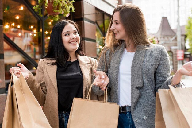 Mejores amigos con bolsas de compras al aire libre