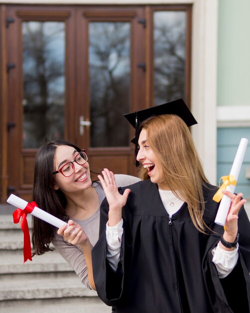 Mejores amigos en la ceremonia de graduación al aire libre