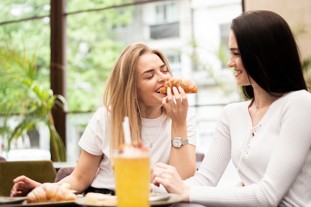 Foto gratuita mejores amigos comiendo un croissant