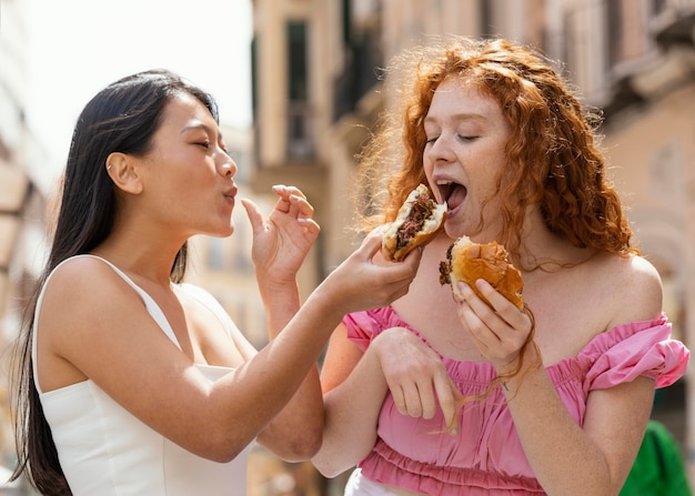 Mejores amigos comiendo juntos algo de comida callejera