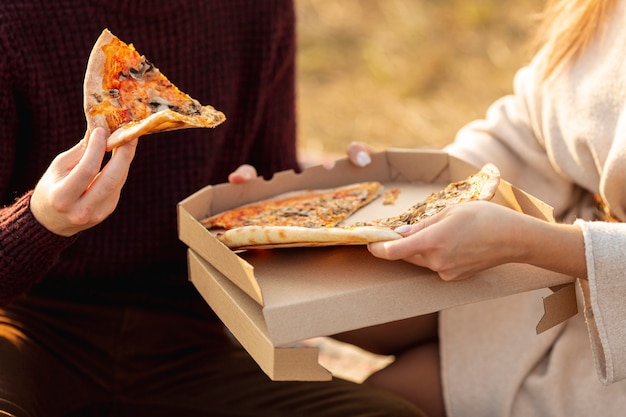 Mejores amigos disfrutando de una pizza juntos fuera de primer plano