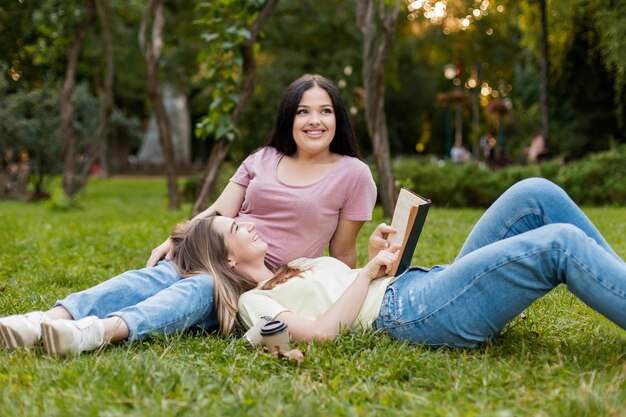 Mejores amigos disfrutando de su día libre mientras se quedan en el césped