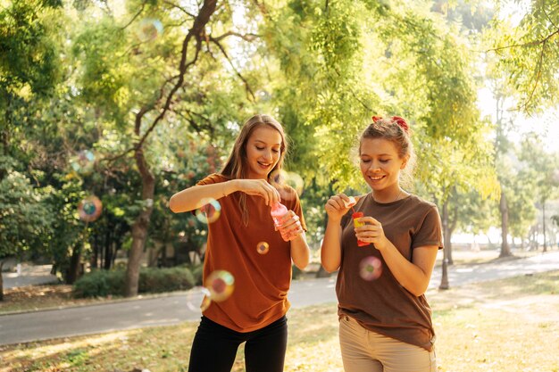 Mejores amigos haciendo pompas de jabón al aire libre