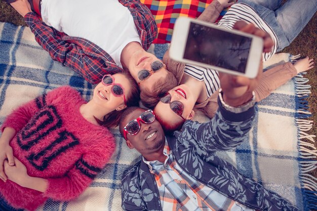 Mejores amigos haciendo selfies en un teléfono móvil o inteligente.