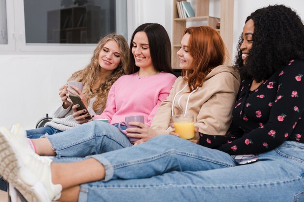 Mejores amigos mirando el teléfono de una chica