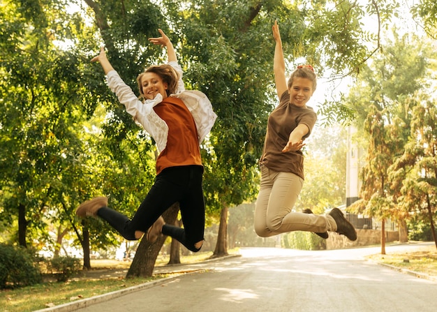 Mejores amigos saltando al aire libre