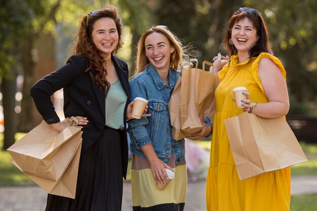 Mejores amigos sosteniendo bolsas de compras afuera