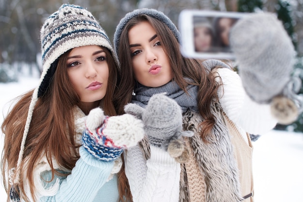 Mejores amigos tomando selfie en invierno
