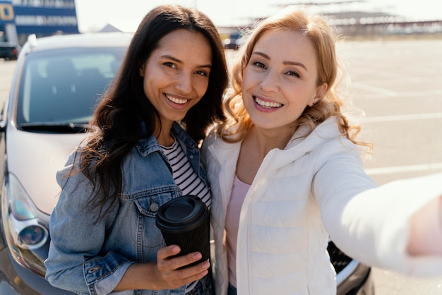 Mejores amigos tomando una selfie con su coche