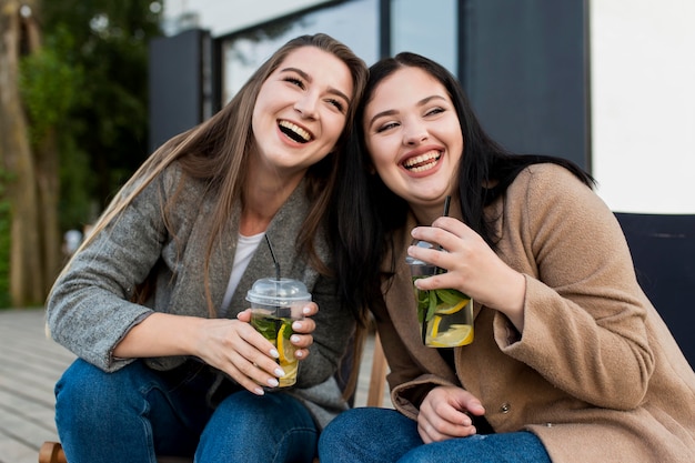 Foto gratuita mejores amigos de vista frontal disfrutando de unos cócteles