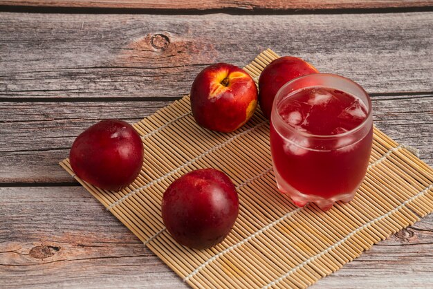 Melocotones rojos con una taza de bebida helada