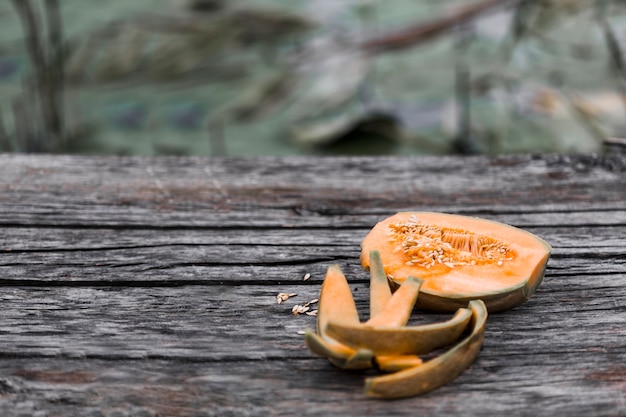 Melón de almizcle comido y reducido a la mitad en una mesa de madera desgastada