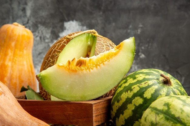 Melón fresco de vista frontal con calabaza y sandía en el fondo oscuro