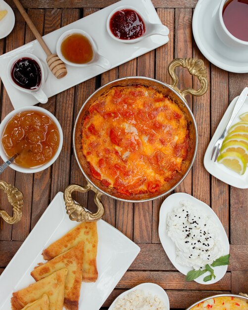 Menemen turco en sartén de cobre sobre una mesa de desayuno.