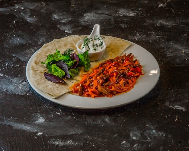 Menestra de verduras en salsa de tomate con hierbas, lavash y salsa blanca.