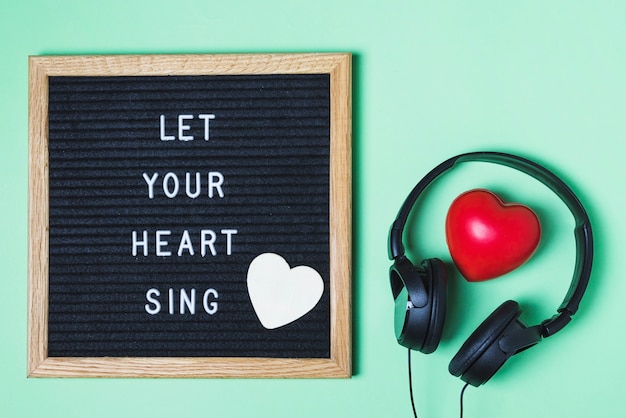 Mensaje a bordo; corazón rojo y auriculares en fondo verde