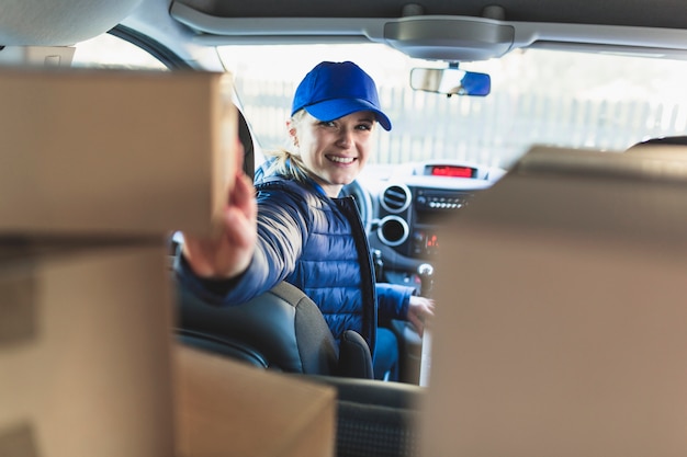 Foto gratuita mensajero alegre en coche