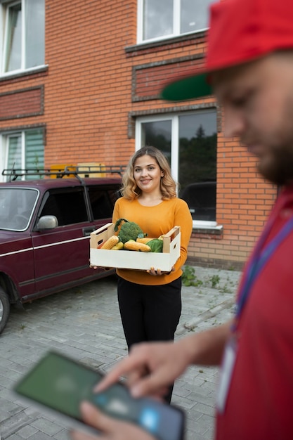 Foto gratuita mensajero entregando comestibles a casa