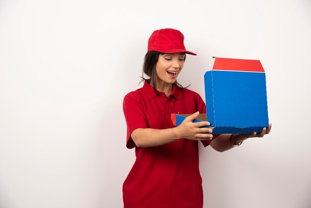 Mensajero femenino abriendo una caja de pizza