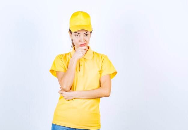 Mensajero femenino en uniforme amarillo parece pensativo.