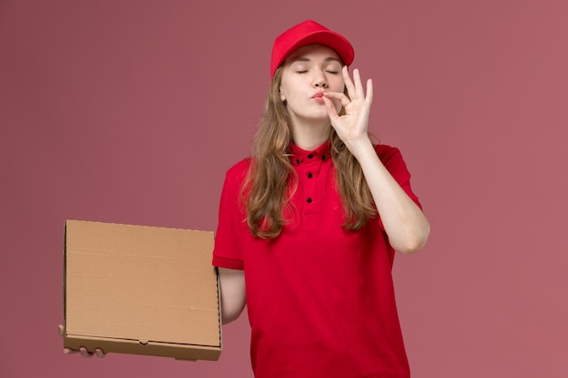 Mensajero femenino en uniforme rojo con caja de comida en rosa, trabajador de trabajo de entrega de servicio uniforme