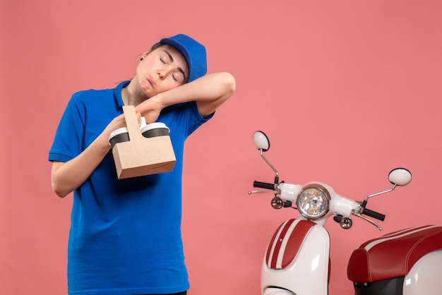 Mensajero femenino de vista frontal con café de entrega en bicicleta de mujer trabajadora de servicio uniforme de entrega de trabajo rosa