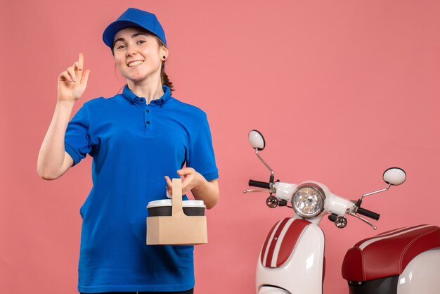 Mensajero femenino de vista frontal con café de entrega en bicicleta de mujer de trabajo de servicio uniforme de entrega de trabajo rosa