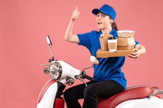 Mensajero femenino de vista frontal con paquetes de alimentos y cajas en servicio de bicicleta de entrega de alimentos de color rosa trabajo trabajador