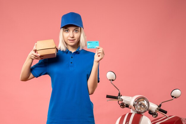 Mensajero femenino de vista frontal con tarjeta bancaria y pequeño paquete de comida en rosa