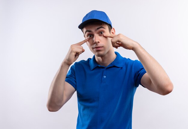 Mensajero joven con uniforme azul y puntos de gorra azul en los ojos