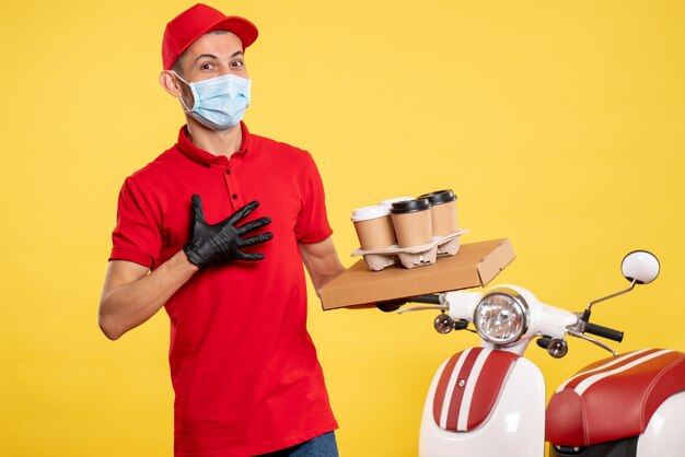 Foto gratuita mensajero masculino de vista frontal con caja de comida y café de entrega en color de trabajo de servicio amarillo claro uniforme de trabajo de pandemia de virus covid