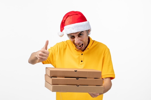 Mensajero masculino vista frontal con cajas de pizza en la pared blanca uniforme de servicio de trabajo año nuevo