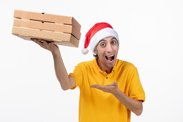 Mensajero masculino de vista frontal con cajas de pizza en el servicio de entrega uniforme de escritorio blanco