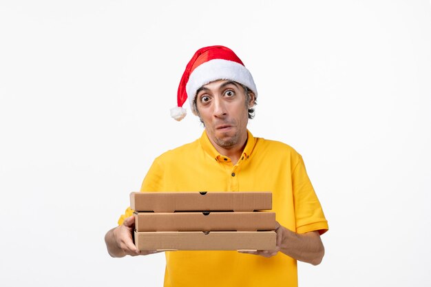 Mensajero masculino de vista frontal con cajas de pizza en el servicio de entrega uniforme de trabajo de escritorio blanco claro