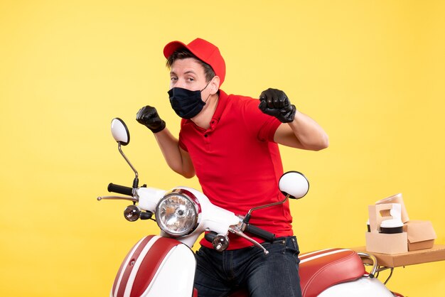 Mensajero masculino de vista frontal en guantes uniformes y máscara en amarillo