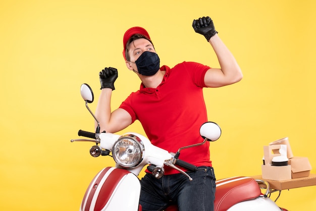 Mensajero masculino de vista frontal en guantes uniformes y máscara en amarillo