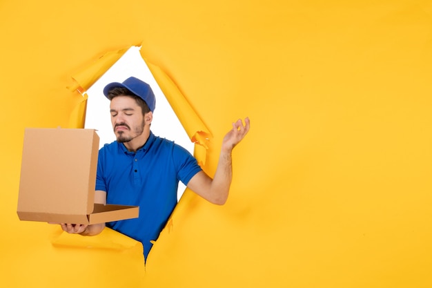 Mensajero masculino de la vista frontal que sostiene la caja de pizza abierta en el espacio amarillo