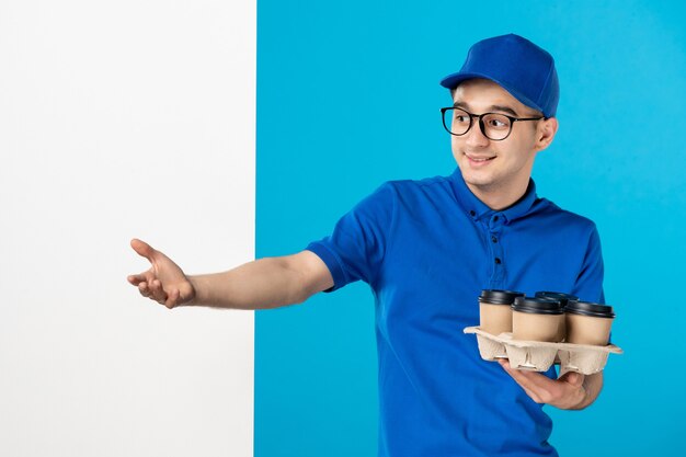 Mensajero masculino vista frontal con tazas de café en azul