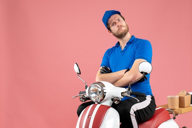 Mensajero masculino de vista frontal en uniforme azul en color rosa trabajo de entrega de bicicletas de alimentos trabajo de comida rápida