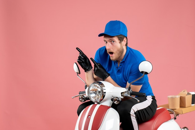Mensajero masculino de vista frontal en uniforme azul en color rosa trabajo servicio de bicicleta de comida rápida entrega de trabajo de comida