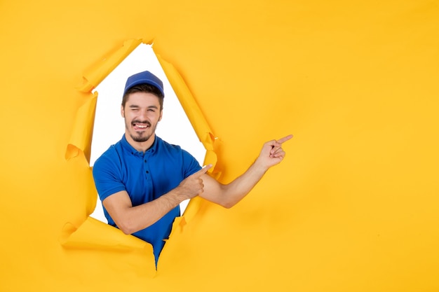 Foto gratuita mensajero masculino de vista frontal en uniforme azul en el espacio amarillo