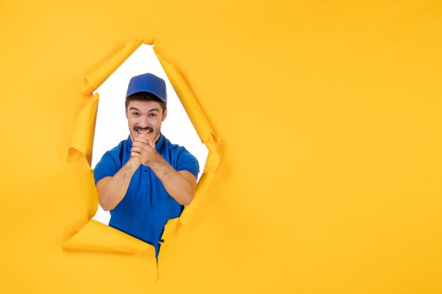 Mensajero masculino de vista frontal en uniforme azul en el espacio amarillo