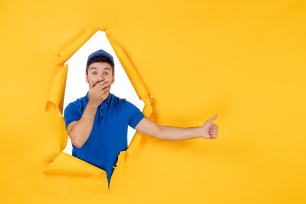 Mensajero masculino de vista frontal en uniforme azul en el espacio amarillo