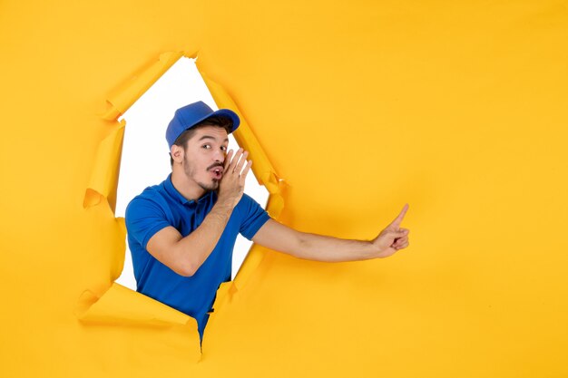 Mensajero masculino de vista frontal en uniforme azul en el espacio amarillo