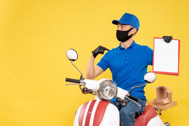 Mensajero masculino de vista frontal en uniforme azul con nota de archivo en servicio de virus trabajo covid- trabajo bicicleta amarilla