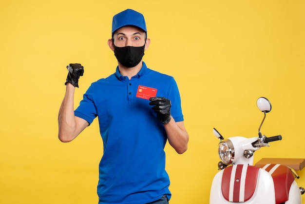 Mensajero masculino de vista frontal en uniforme azul con tarjeta bancaria en uniforme de servicio de trabajo amarillo covid- color de entrega de trabajo