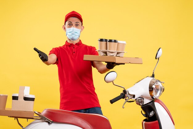 Mensajero masculino de vista frontal en uniforme con caja de café y comida en un servicio de trabajo de color de virus de trabajo uniforme de covid pandemia amarilla